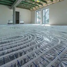 Instalacja ogrzewania podłogowego na 100m2. Rury ułożone na folii izolacyjnej, gotowe do zalania wylewką.