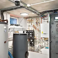Kotłownia z dwoma bojlerami, kotłem gazowym i szafą sterowniczą. Czy ogrzewanie gazowe jest drogie? To zależy od wielu czynników, ale ta instalacja wygląda na wydajną.