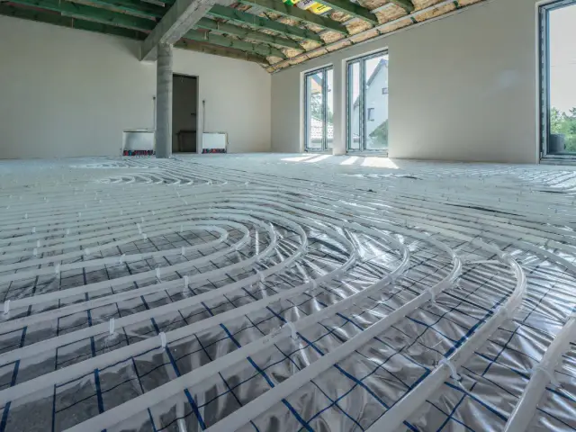 Instalacja ogrzewania podłogowego na 100m2. Rury ułożone na folii izolacyjnej, gotowe do zalania wylewką.