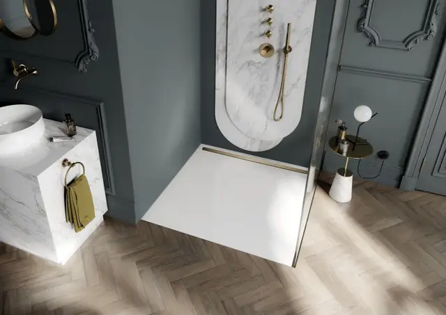Elegancka łazienka z prysznicem walk-in, umywalką na marmurowej podstawie i złotymi akcentami. Wygodne **gniazdka w łazience** dyskretnie wkomponowane w wystrój.